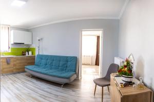 a living room with a blue couch and a kitchen at Casa Schubert3 in Oradea