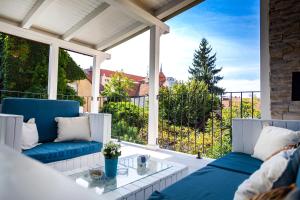 a porch with two blue chairs and a glass table at Casa Schubert3 in Oradea +8 photos