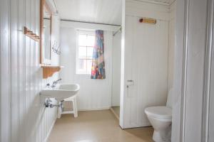 a white bathroom with a toilet and a sink at Sauda Fjord Camping in Saudasjøen