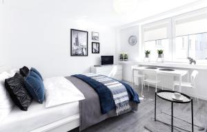 a bedroom with a white bed and white walls at Warsawrent Apartamenty Centralna in Warsaw