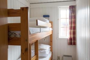 two bunk beds in a small room with a window at Sauda Fjord Camping in Saudasjøen