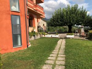 een grasveld naast een huis met een bakstenen pad bij Affittacamere Il Colle in Faicchio