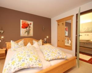 une chambre avec un lit avec des oreillers et un miroir dans l'établissement Landhaus Wild, à Riezlern