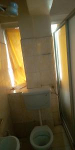 a small bathroom with a toilet and a window at Hotel Jaffers Nairobi in Nairobi