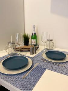 two plates on a table with glasses and wine bottles at Appartment Stadtgarten in Tuttlingen