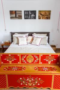 Un dormitorio con una cama con diseños rojos y dorados en Grand Accommodation Apartments, en Bucarest