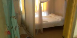 a small bedroom with a bed and a window at Hotel Jaffers Nairobi in Nairobi