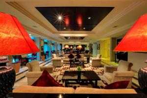 a hotel lobby with couches and tables and red lamps at Century Park Hotel in Amman