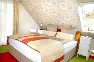 ein Schlafzimmer mit einem großen weißen Bett und einem Fenster in der Unterkunft Villa Luisa in Timmendorfer Strand