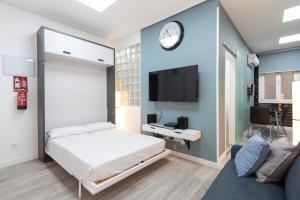 1 dormitorio con 1 cama y reloj en la pared en Plaza Mayor Apartment, en Madrid
