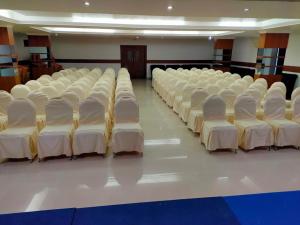 a room with rows of white chairs lined up at Paray Village County in Kollengode