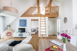 a room with a loft bed and a living room at Apartmenthaus am Erlbach in Buch am Erlbach