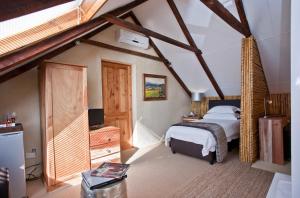 a bedroom with a bed and a tv in a attic at Surval Boutique Olive Estate in Oudtshoorn