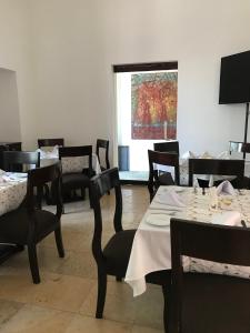 un comedor con mesas y sillas y una ventana en Hotel Casa las Mercedes en Oaxaca de Juárez