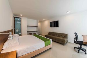 a bedroom with a bed and a couch and a television at Altoprado Popayán in Popayan