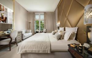 a hotel room with a large bed and a large window at Hôtel Barrière Fouquet's Paris in Paris
