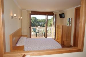a bedroom with a bed and a view of a patio at Apartamentos Ay Sálvora in O Grove +52 photos