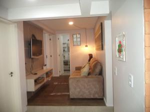 a living room with a couch and a tv at House Flat Cacupé em Florianópolis in Florianópolis