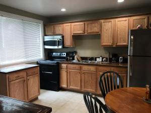 a kitchen with wooden cabinets and a black refrigerator at Mon Chateau in Peoria