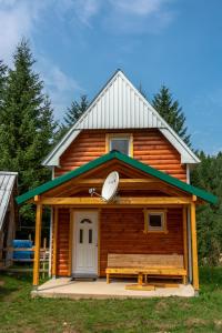 uma cabana de madeira com um banco à frente em Small Montenegro em Žabljak