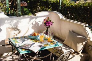a table with flowers and drinks on a patio at B&B Orto Paradiso in Minori