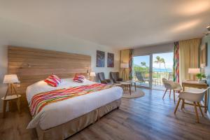 um quarto de hotel com uma cama, uma mesa e cadeiras em La Playa Orient Bay em Orient Bay