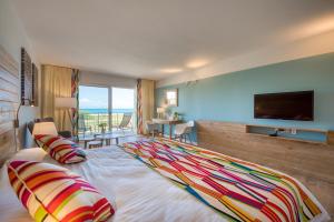 a hotel room with a large bed with a colorful blanket at La Playa Orient Bay in Orient Bay
