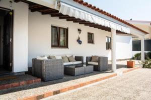 a patio with wicker furniture on a house at Casa da Quintinha - Villa with a pool in Sesimbra