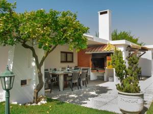 a patio with a table and chairs and a house at Casa da Quintinha - Villa with a pool in Sesimbra