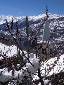 a small church with a snow covered mountain in the background at La Cure de Vernamiège in Vernamiège