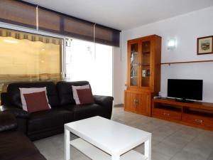 a living room with a couch and a tv at Apartamentos Medano - Estrella del Mar in El Médano