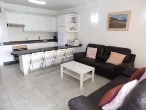 een woonkamer met een bank en een keuken bij Apartamentos Medano - Estrella del Mar in El Médano