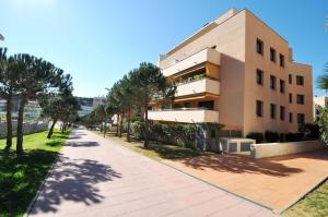 a building with a sidewalk in front of it at Apartment Arigata in Lloret de Mar