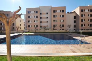 une grande piscine en face d'un bâtiment dans l'établissement Apartment Arigata, à Lloret de Mar