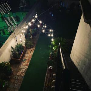 uma vista sobre um jardim à noite com luzes em B&B Camelot em Palermo