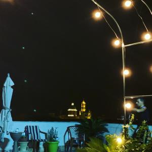 a man is standing on a patio at night at B&B Camelot in Palermo