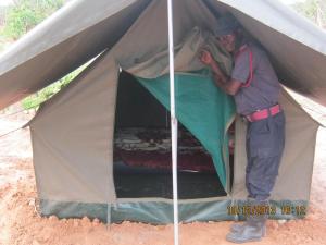 Un homme se tient à l'intérieur d'une tente dans l'établissement Lochinvar Safari Lodge of Lochinvar National Park - ZAMBIA, à Lochinvar National Park