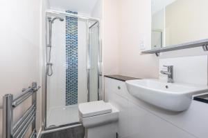 a bathroom with a toilet and a sink and a shower at Magna House in Egham
