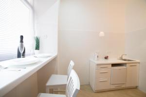 リヴィウにあるMini-Smart economy apartment on Saint Teodor 5の白いバスルーム(シンク、白い椅子付)