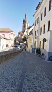 a cobblestone street in a town with a clock tower at Amedeea's Apartment in Sibiu