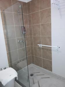 La salle de bains est pourvue d'une douche en verre et de toilettes. dans l'établissement Hotel de Campo Posada la Esperanza, à Río Cuarto