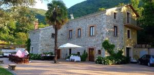 un grande edificio in pietra con una palma di fronte di Masseria boutique b&b a Montella