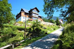 una casa grande en una colina con una carretera en Ferienhaus Kühlwein, en Bad Goisern