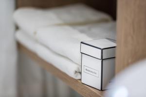 a box on a shelf next to a bed at Hotel Plankenhof B&B in Pill