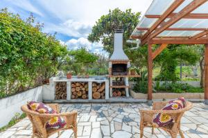 un patio con focolare, 2 sedie e un tavolo di Chitaka's Organic Farmhouse in Ribatejo a Santo Estêvão