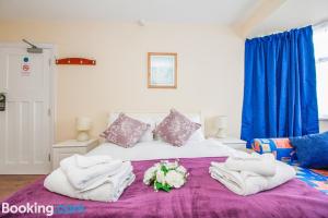 ein Schlafzimmer mit einem Bett mit Handtüchern und Blumen darauf in der Unterkunft Harris Guest Accommodation in Oxford