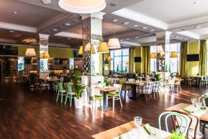 モスクワにあるホテル ポクロフスコエ ストレシネヴォのテーブルと椅子が備わるウッドフロアのレストランを併設しています。