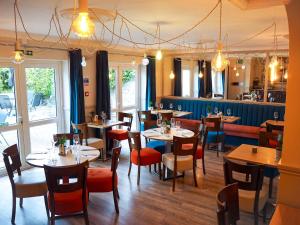 a restaurant with tables and chairs in a room at Hayward's at the Grasmere in Keynsham