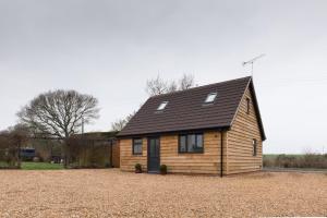 a small wooden house with a black roof at Coach House in Milton Keynes