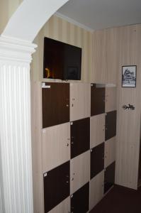 Habitación con TV en la pared y estante en Hostel Green City Tyumen, en Tyumen